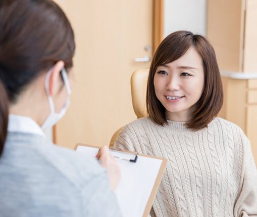 A female patient talking with her dentist about cosmetic bonding in Carrollton, TX