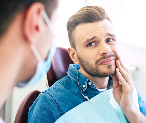 Man with dental pain visiting his Carrollton emergency dentist