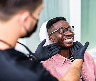 Dentist looking at smiling patient's teeth