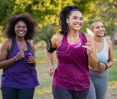 Group of women smiling while jogging in park
