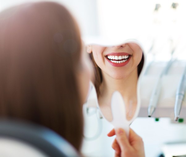 Woman looking at smile after dental treatment