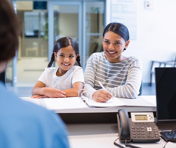 Mother and daughter checking in at dental office front desk