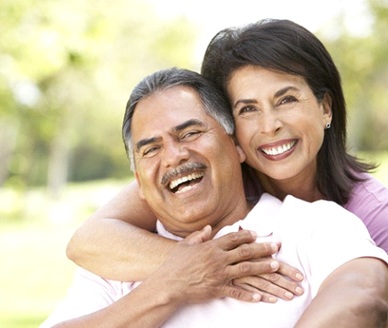 Smiling couple with dental implants in Carrollton