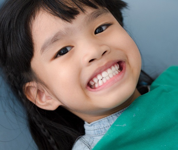 Child smiling after fluoride treatment