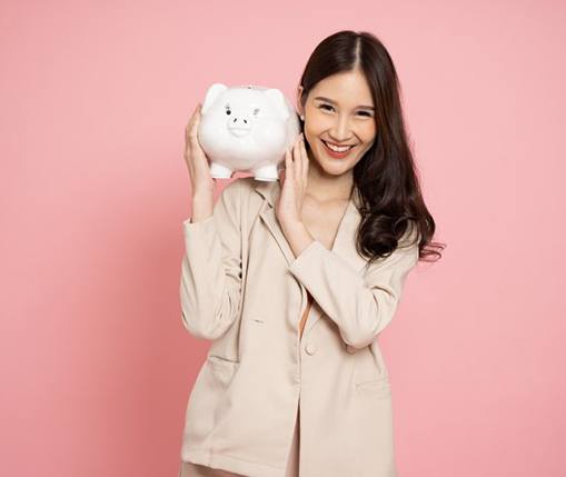 Woman smiling while holding a large piggy bank