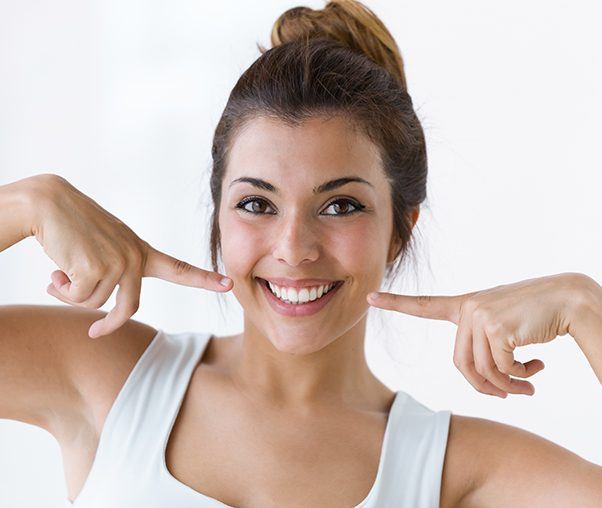 Woman pointing to smile after teeth whitening