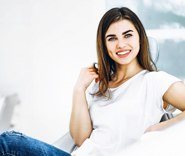 Woman smiling with dental crowns in Carrollton while sitting