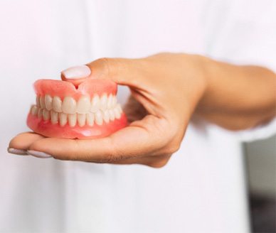 Dentist holding full dentures