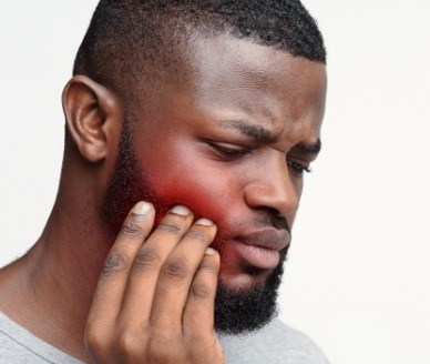 Man with toothache holding cheek