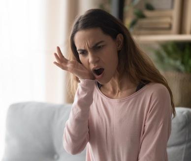 Woman with jaw pain holding her cheek