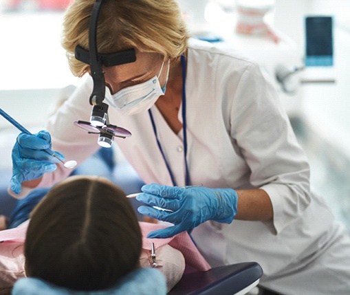 A dentist performing gum recontouring on a patient during an appointment