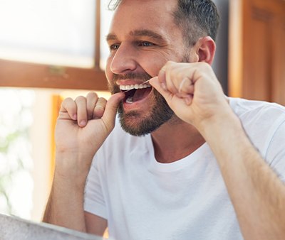 Man flossing his teeth