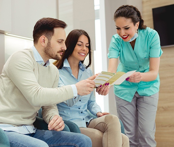 Dental team member showing patients dental insurance forms