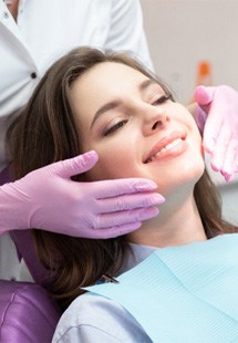 patient smiling while looking in dental mirror 