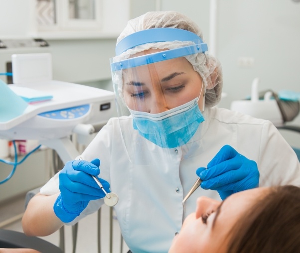 Dental team member treating a patient while wearing face shield