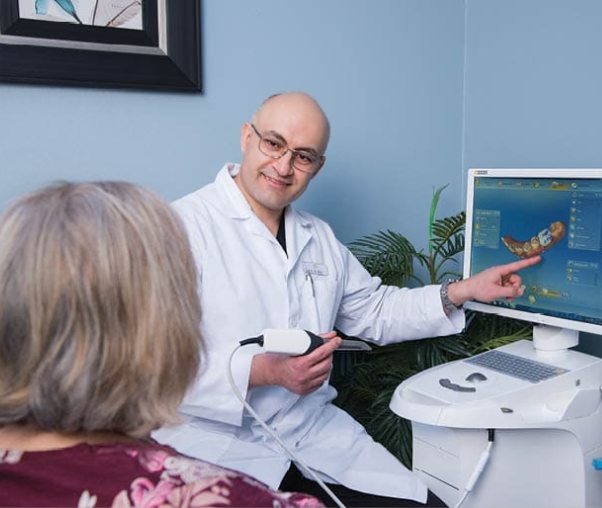 Carrollton dentist pointing to digital impressions of patient's teeth on computer screen