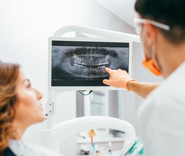 Dentist and patient looking at digital x-rays