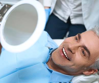 Man admiring his new veneers in Carrollton