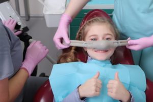 Little girl gives thumbs up before nitrous oxide sedation for kids in Carrollton