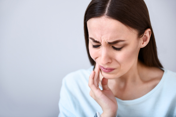 woman with a dental problem, hand to cheek