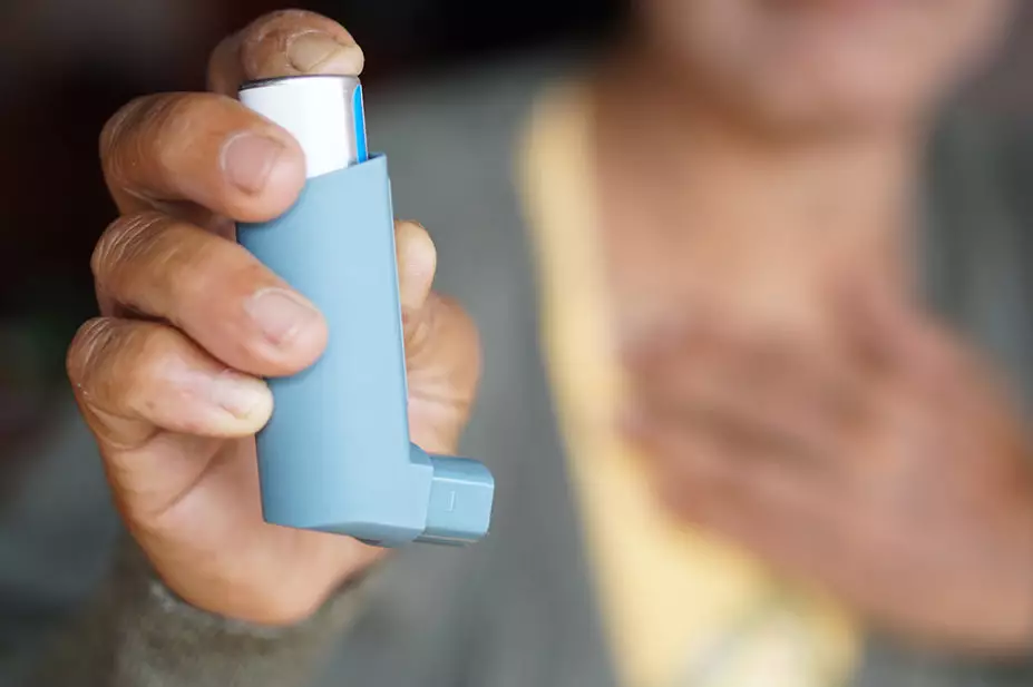 person with asthma holding inhaler 