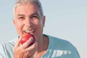 Older man biting an apple