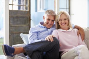 senior man and woman sitting on couch 