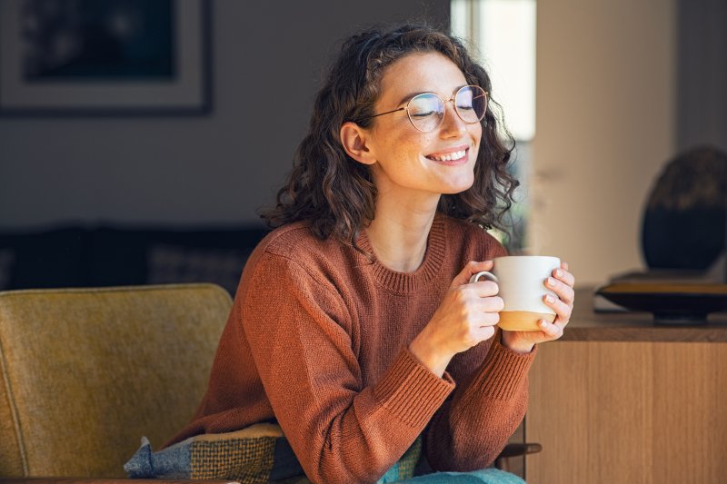 Woman enjoying a cup of coffee after tooth extraction
