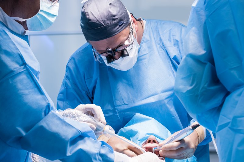 dentists performing oral surgery on patient 