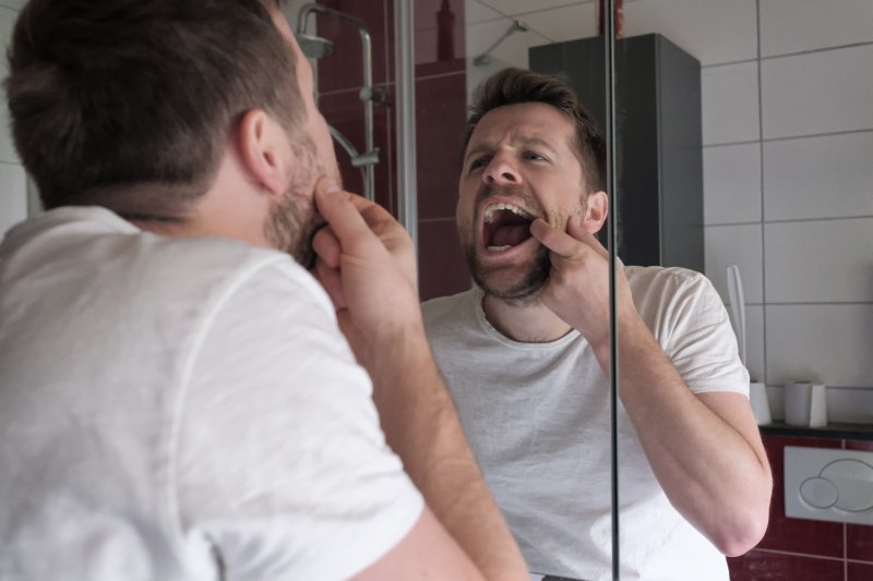 Patient checking loose tooth in the mirror